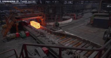 Demir dökümhanesi. Üretimde yuvarlanan metal, sıcak metal kurdele, top üretim aşaması, metal rulo fabrikasında üretim süreci, ışıldayan metal silindirlerin arasında yuvarlanan...