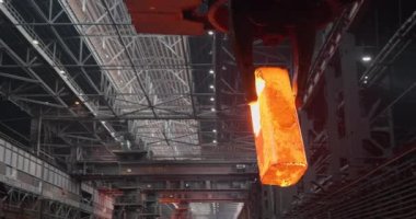 Vinç erimiş çelikten bir kalıp veriyor ve nakil için bir tramvaya koyuyor. Metalürjik bitki. Yuvarlanan dükkan. İş konsepti, modern çelik üretim teknolojisi