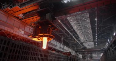 Vinç erimiş çelikten bir kalıp veriyor ve nakil için bir tramvaya koyuyor. Metalurjik bitki. Yuvarlanan dükkan, açan çiçekler. İş konsepti, modern çelik üretim teknolojisi.