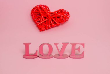 Aşk ve kırmızı kalbin pembe ahşap harfleri. Tebrik mesajı için bir pankart konsepti.