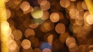 Bokeh Yeni Yıl çelenkleri. Sokak Noel süsleri. Odak dışı altın sarısı ışıklar.