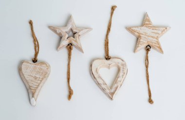 Kalp ve yıldız şeklinde dekoratif ahşap süsler, beyaz arka planda izole edilmiş..