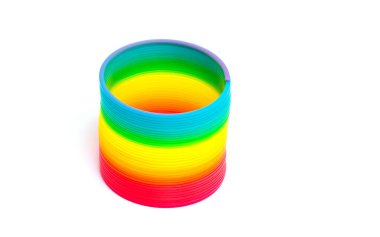 Beyaz arkaplanda izole edilmiş renkli oyuncak gökkuşağı spirali.