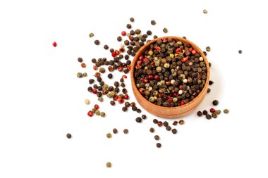Biberlikte farklı biber taneleri ve beyaz arka planda izole edilmiş bir isilik karışımı. Yemek pişirmek için aromatik baharatlar.