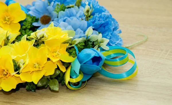 用乌克兰国旗的彩带将黄色和蓝色花朵装饰成的花束围在一起 — 图库照片