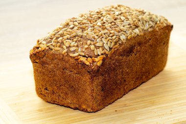 Ahşap bir masada ayçiçeği tohumlu siyah çavdar ekmeği..