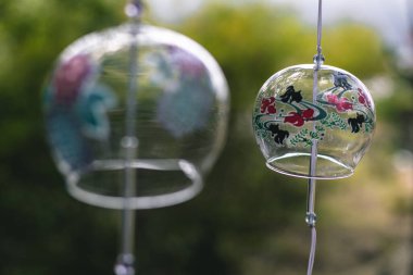 Edo rüzgar çanları ağaçlarla çevrili yaklaşma yolunda sallanıyor.