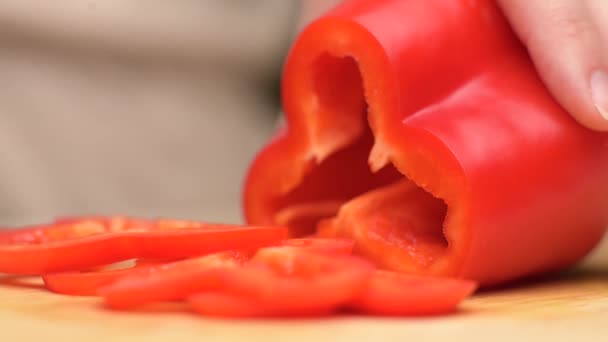 Woman slicing red sweet pepper on kitchen board — Stock Video