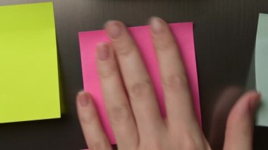 Young woman puts a sticker on the refrigerator, the camera zooms back