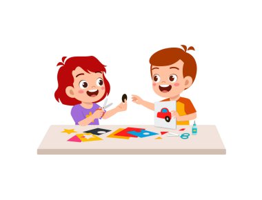 Küçük çocuk arkadaşlarıyla sanat için kağıt kesiyor.