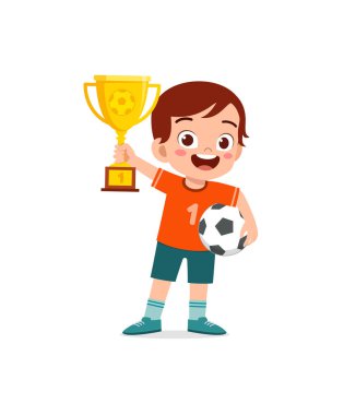 Küçük çocuk futbol yarışmasını kazandı ve elinde kupa var.