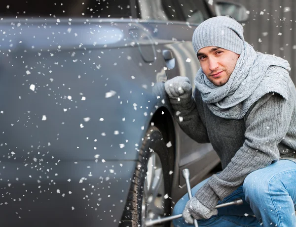 Young man changing a car wheel — Stock Photo, Image