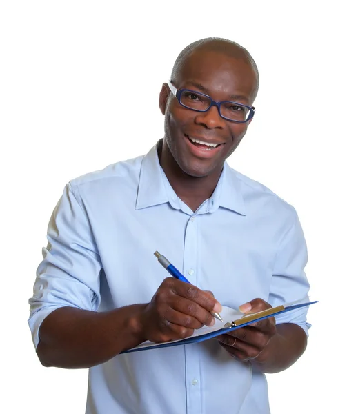 Homem de negócios africano escrevendo notas em uma área de transferência — Fotografia de Stock