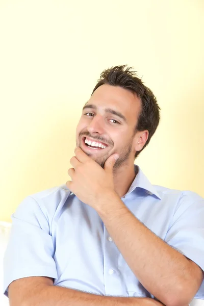 Riendo hombre latino en la sala de estar mirando a la cámara — Foto de Stock