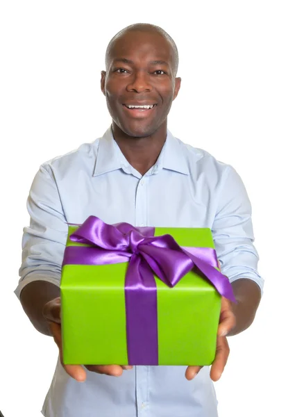 Rindo homem africano mostrando um presente para o Natal — Fotografia de Stock