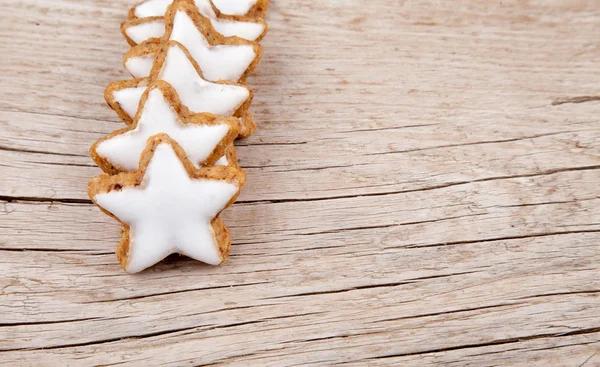 Line of cinnamon stars for christmas on wood — Stock Photo, Image