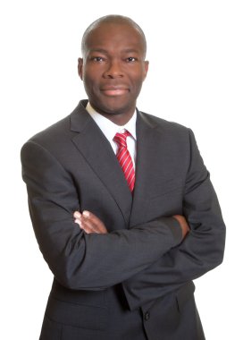 kameraya gülümseyen çapraz kolları olan Afrika iş adamı