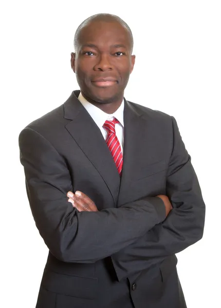 African businessman with crossed arms smiling at camera — Stock Photo, Image