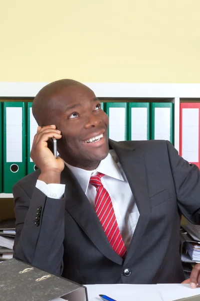 Laughing african businessman at phone — Stock Photo, Image