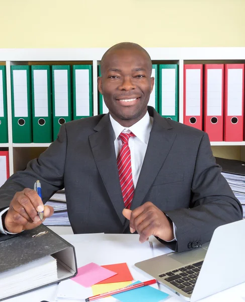 Skrattar afrikanska affärsman på hans kontor — Stockfoto
