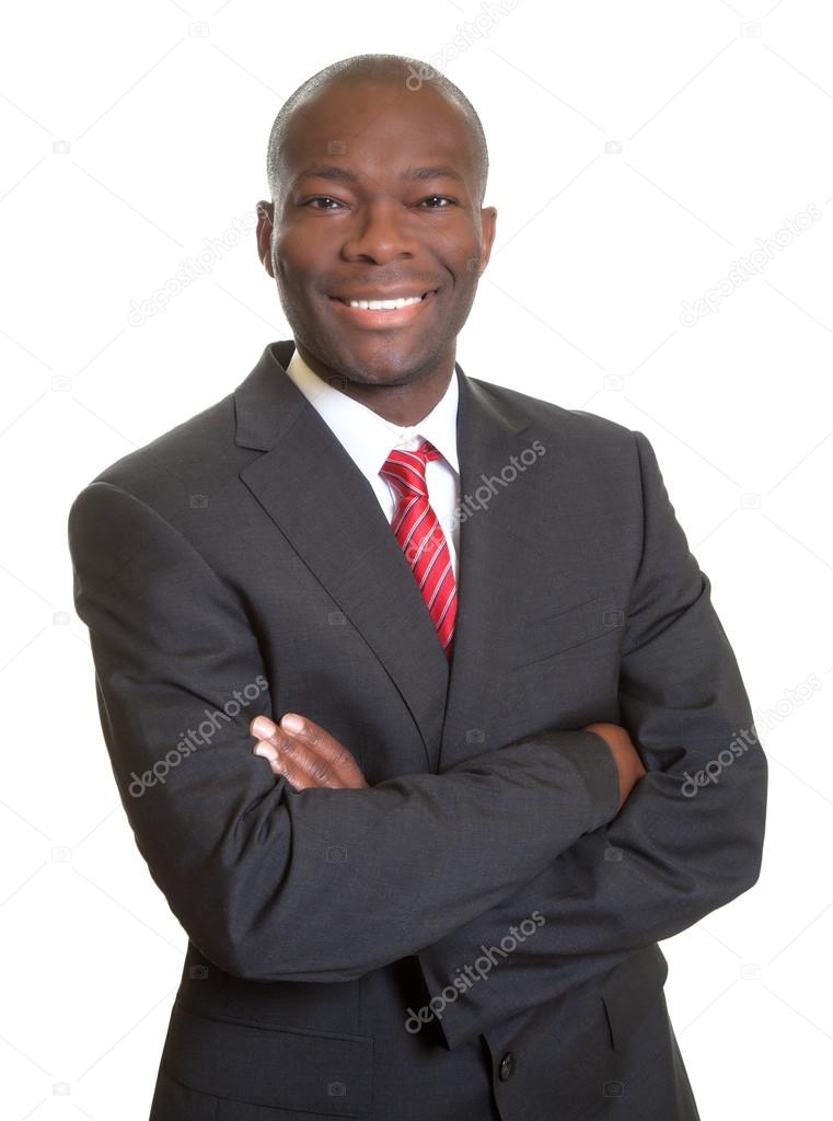 African businessman with crossed arms laughing at camera