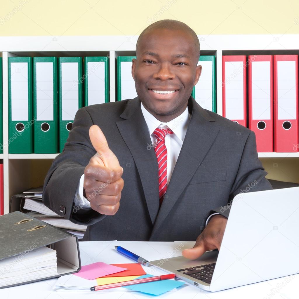 African businessman showing thumb up at his office