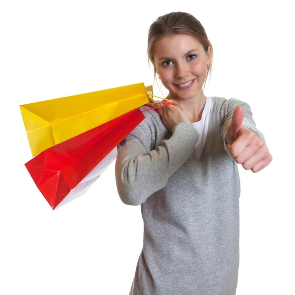 Laughing woman with shopping bags showing thumb up — Stock Photo, Image