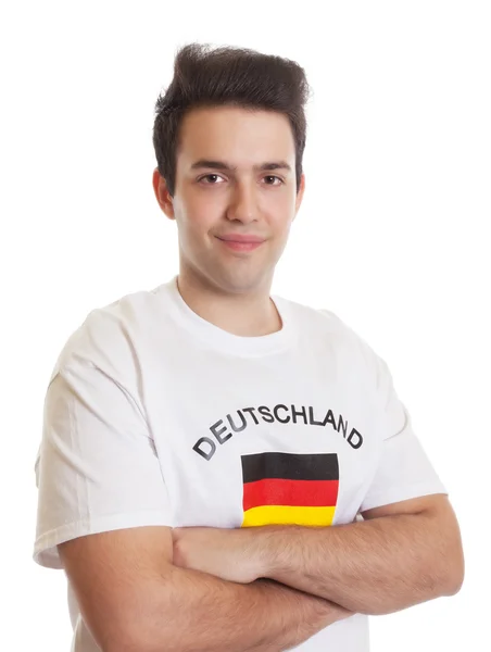 Улыбающийся немецкий спортивный фанат со скрещенными руками — стоковое фото