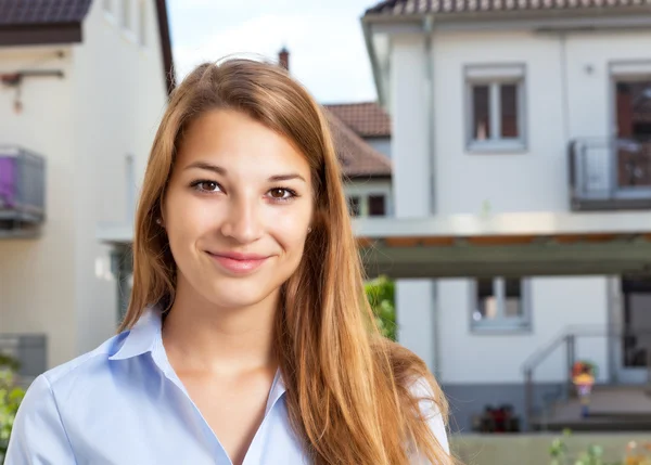 Portrait of a young woman in front of a building — Stock Photo, Image