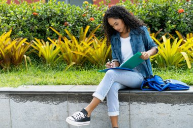Ciddi Brezilyalı kız öğrenci yaz kampüsünde öğreniyor.