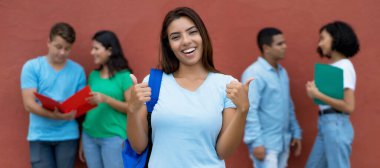 İyimser Meksikalı kız öğrenci yaz aylarında çok ırklı öğrencilerle dışarıda.