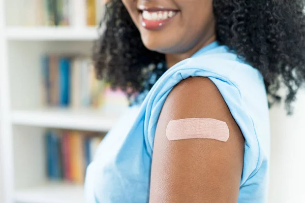 在第三次接种Covid 19疫苗后 为了防止欧米克隆变种 在拉丁裔美国妇女的胳膊上贴上了近身石膏 — 图库照片