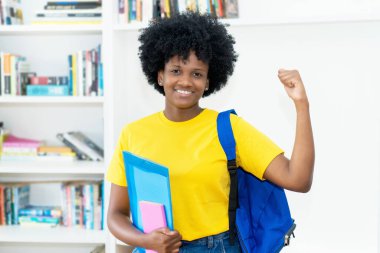 Üniversitede sarı gömlekli Afro-Amerikan kız öğrenci.
