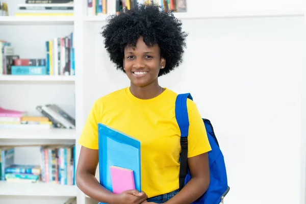 美しい笑いアフリカ系アメリカ人女性学生と黄色のシャツで大学 — ストック写真
