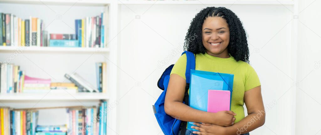 Corpulent african american female student with green shirt at classroom of university