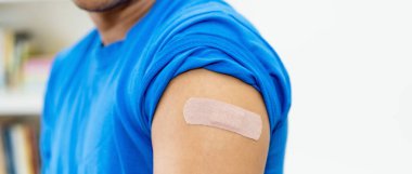 Arm of man with plaster after vaccination with copy space clipart
