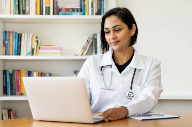 Latin Amerikalı olgun doktor hastanede bilgisayarın başında.