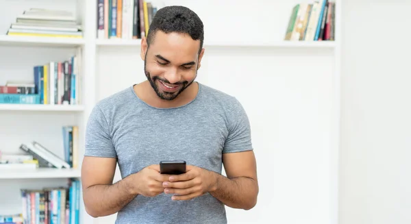 Laughing Hispanic Hipster Man Beard Sending Message Mobile Phone Indoors — Photo