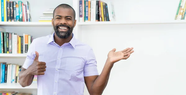Mature african american businessman with beard pointing sideways indoors at office