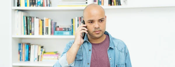 Serious Bald Man Listening Mobile Phone Indoors Home — Stockfoto