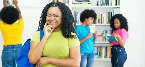 アフリカ系アメリカ人の女子大生を図書館で屋内で笑っています — ストック写真