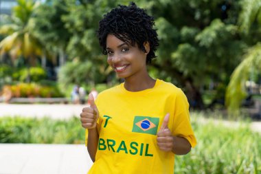 Şehirde sarı formalı güzel Brezilyalı bayan futbol fanatiği.