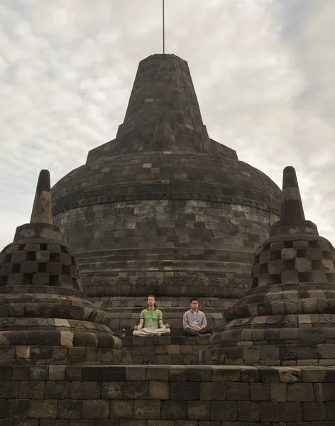 Yogyakarta, Indonesia-January 2009: Two men meditated on big Pagoda at Borobudur Temple. — Stock Photo, Image