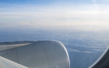 Uçak penceresinden bak. Arka planda birçok bulutla.
