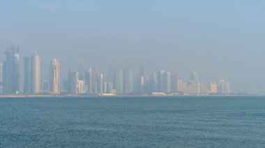 Doha Katar 'da puslu bir sabahta pek çok ikonik kule ve builiye sahip Westbay bölgesinin manzarası