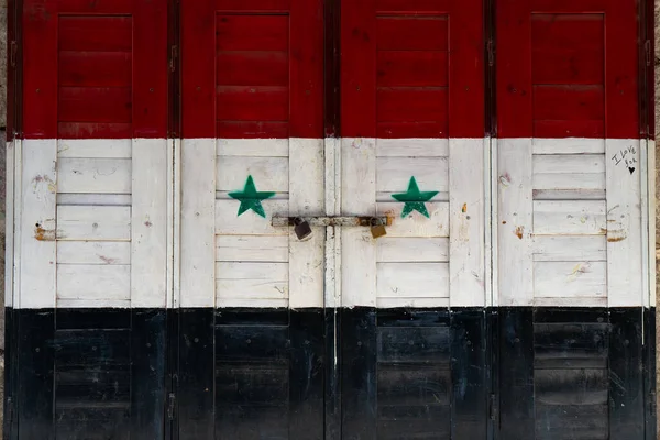 Syrain flag painted on a door at a shop in damascus market