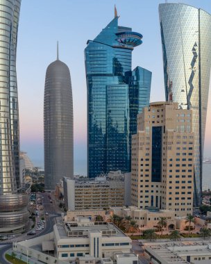 Doha, Katar - Mart 03.2022: Gün batımında renkli gökyüzü ile Katar silueti.