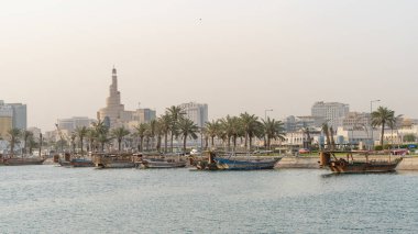 Multiple wooden traditional fishing dhows docked in the doha corniche.