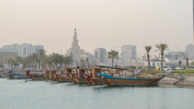 Multiple wooden traditional fishing dhows docked in the doha corniche.