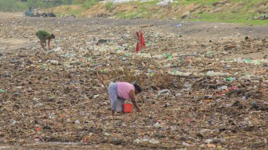 Colombo, Sri Lanka - 08 Ağustos 2022; Kadınlar çöp satmak için çöpten metal eşyalar topluyor.